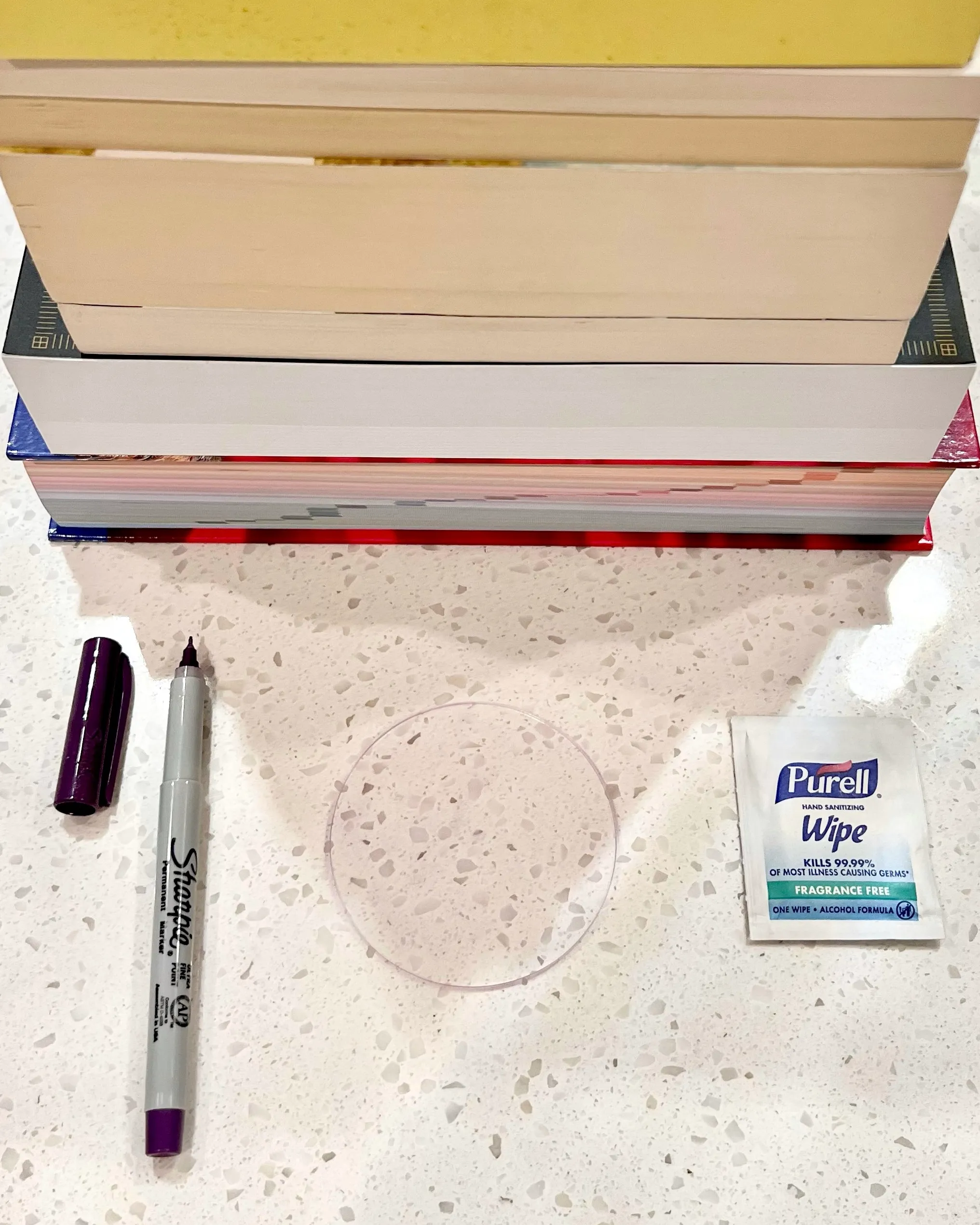 Phone, acrylic circle, books, Sharpie, and alcohol wipe for the DIY cookie projector