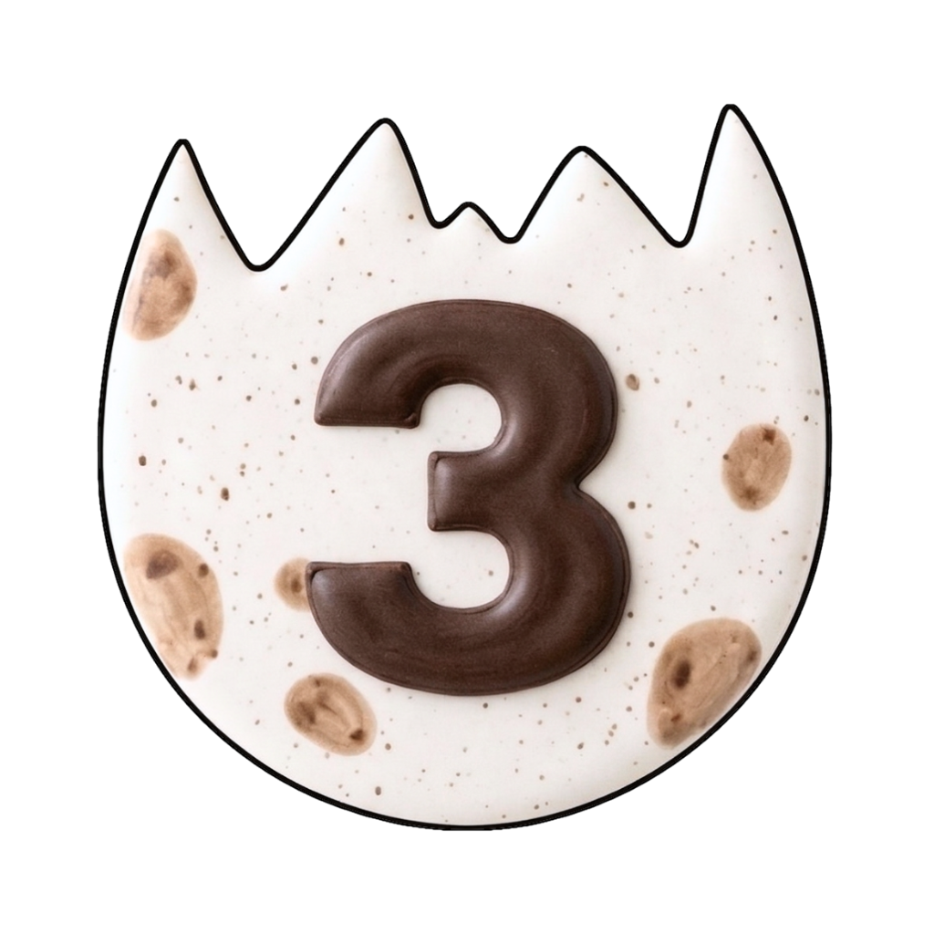 Speckled dinosaur egg plaque cookie with a dark brown number 3 centered on the shell
