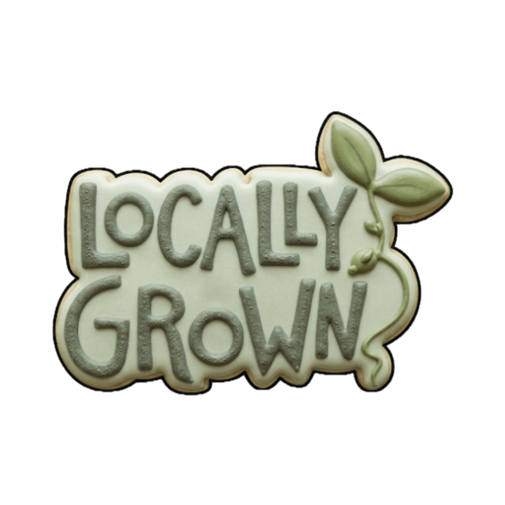 Plaque cookie that says locally grown with small green leaves